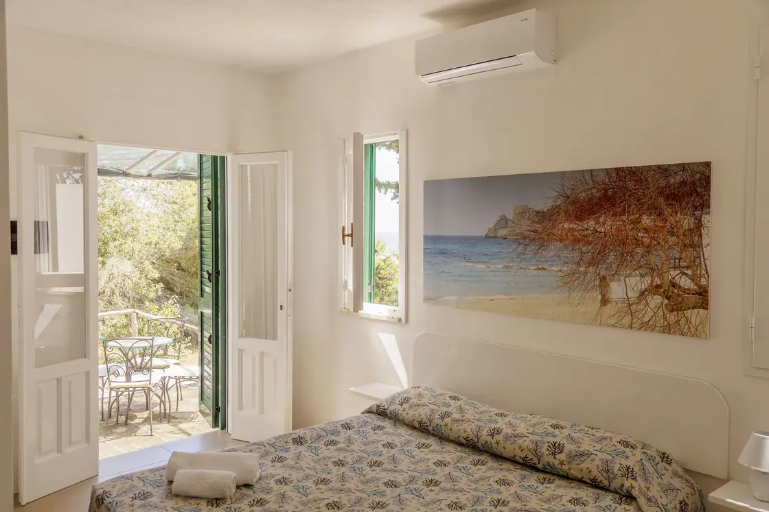 Interno del bungalow con la porta aperta sulla pineta