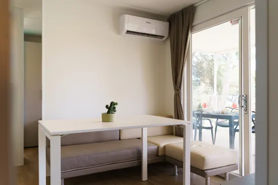Zona pranzo con tavolo e porta aperta sulla terrazza
