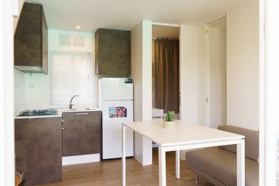 Angolo cucina con frigorifero e piano cottura
